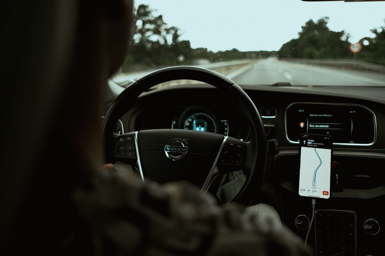 services-01 Interior view of a car on the highway using a GPS navigation app on a smartphone